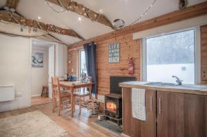 a kitchen with a fireplace and a table and a stove at The Lodge - 1 Bedroom - Freshwest Beach Retreat in Pembroke