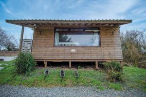 a small house with a window and a pair of shoes at The Hygge Hut - 1 Bed - Freshwest Beach Retreat in Pembroke