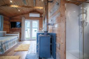 a room with a wood paneled wall with a stove at The Hygge Hut - 1 Bed - Freshwest Beach Retreat in Pembroke