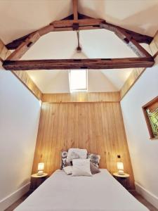 1 dormitorio con 1 cama blanca y paredes de madera en Maison Vanier - Duplex - centre-ville - Mon Groom, en Troyes
