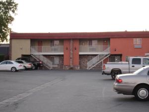 a parking lot with cars parked in front of a building at Travelers INN in West Sacramento