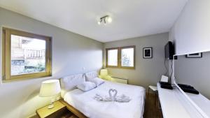 ナンダにあるAppaloosa FABULOUS & LUXE chalet 12 persのベッドルーム(白いベッド1台、テレビ付)