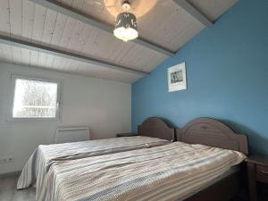 um quarto com uma cama grande e uma parede azul em Maison Barbâtre, 4 pièces, 6 personnes - FR-1-224B-548 em Barbâtre