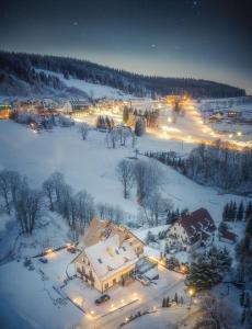 een huis bedekt met sneeuw 's nachts met lichten bij Orlicka Skała in Zieleniec