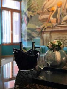 una mesa con dos copas y una botella de vino en Do Leoni Apartments Venice en Venecia