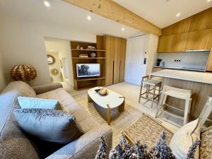 a living room with a couch and a table at Mazet 2 chambres in Ramatuelle