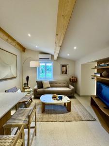 a living room with a couch and a table at Mazet 2 chambres in Ramatuelle