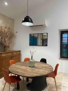 a dining room with a wooden table and chairs at Cottage paisible in Ribérac
