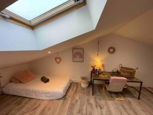 a bedroom with a bed and a desk in a attic at Cottage paisible in Ribérac +14 photos