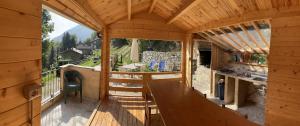 una cabina in legno con tavolo e ampia finestra di vallemaira house GRAN BAITA gruppi 4-14 persone a San Damiano Macra