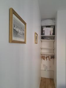 a hallway with white walls and a picture on the wall at Agréable 2 pièces - rue du vieux Versailles in Versailles