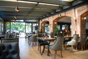 a restaurant with tables and chairs and a brick wall at Sieben Zimmer am See in Prien am Chiemsee