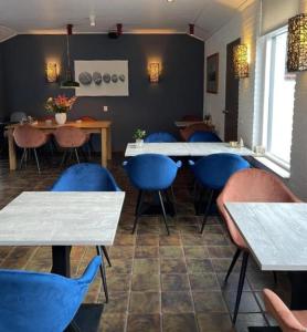 DuinHotel Texel في دي كوخ: غرفة طعام مع طاولات وكراسي زرقاء