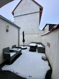 a courtyard covered in snow with couches and a table at Häuschen am Plenzer in Ingelheim am Rhein