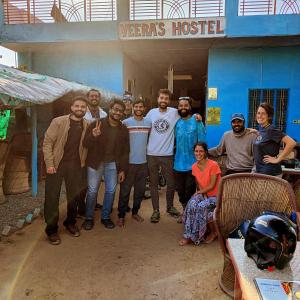 un groupe de personnes posant une photo devant un bâtiment dans l'établissement Veera's Hostel, à Pushkar