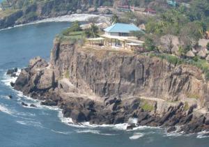 a house on a cliff next to the ocean at Stunning Beach/Cliff side studio in paradise in Tamanique