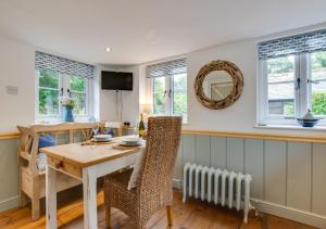 a dining room with a table and chairs and windows at Pendeen Hayloft in Saint Stephen
