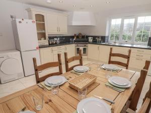 a kitchen with a wooden table with chairs and a dining room at The Granary in Kilgetty