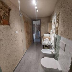 a bathroom with three toilets and two sinks in it at Istanti - Menta in Costigliole Saluzzo +35 photos