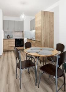 a kitchen and dining room with a table and chairs at Poznań Airport Comfy Apartment in Poznań