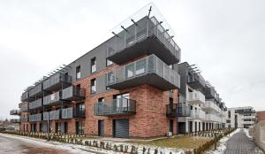 a brick building with balconies on the side of it at Poznań Airport Comfy Apartment in Poznań