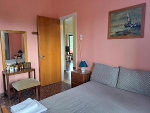 een slaapkamer met een bed, een bureau en een spiegel bij MATINA 2 in Kyparissia
