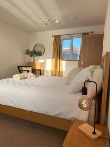 um quarto com uma cama e uma mesa com um candeeiro em Whitebridge Cottage em Swansea