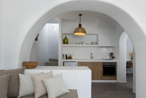 uma cozinha e sala de estar com um sofá e um arco em Archon Seaside Retreat em Plaka