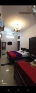 a hotel room with two beds and a television at New hotel blue stars in Varanasi