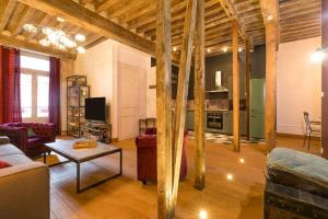 a living room with a couch and a table at L'Escale in Dijon