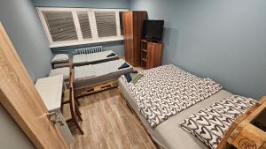 une petite chambre avec deux lits et une fenêtre dans l'établissement Noclegi w Łodzi, Komfortowe Pokoje, Wielkopolska 39, à Łódź