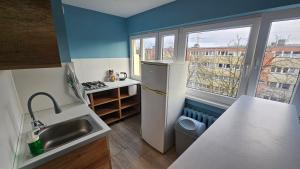 a small kitchen with a sink and a refrigerator at Noclegi w Łodzi, Komfortowe Pokoje, Wielkopolska 39 in Łódź