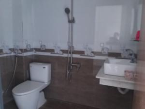 a bathroom with a shower and a toilet and a sink at HP home & coffee in Buon Ma Thuot