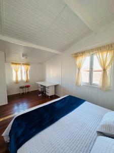 a bedroom with a large bed with a desk and windows at Maktub Lodge - San Pedro de Atacama in San Pedro de Atacama
