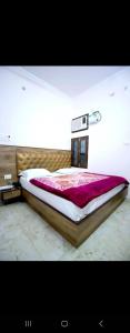 バラナシにあるNew hotel blue starsのベッドルーム(紫の毛布を使用した大型ベッド1台付)