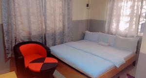 a small bedroom with a bed and a chair at Arena Guest House and Lounge in Ikeja