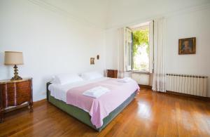 a white bedroom with a bed and a window at B&B Casina de Goyzueta in Torre del Greco