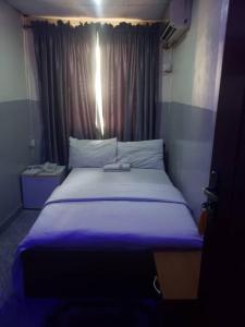 a bedroom with a large bed with purple sheets at Arena Guest House and Lounge in Ikeja