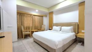 een hotelkamer met een bed en een tafel bij The Sky Imperial Hotel The Maison in Anand