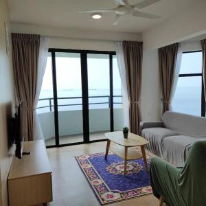 a living room with a couch and a table at Mutiara Melaka Beach Resort by Ally 