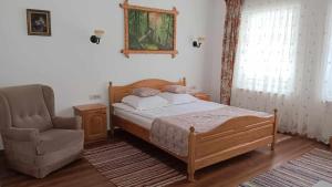 ein Schlafzimmer mit einem Bett und einem Stuhl in der Unterkunft Pensiunea Agroturistica Cristal in Suceviţa