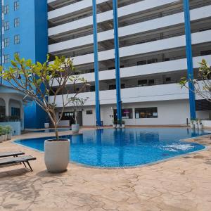a large building with a swimming pool with a potted tree at Mutiara Melaka Beach Resort by Ally 