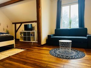 - un salon avec un canapé bleu et une table dans l'établissement Kapitänshaus an der Warnow mit Sauna, à Rostock
