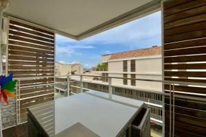 een balkon met een bank en een groot raam bij Le Terrasse en Mer- Air conditioning parking and seaside! in Palavas-les-Flots