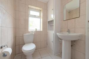 Baño blanco con aseo y lavamanos en 4 BED House IN Dartford 8 Beds Sleeps 10, en Kent