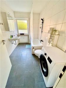 a white bathroom with a washing machine in it at Cozy apartment in Passau in Passau