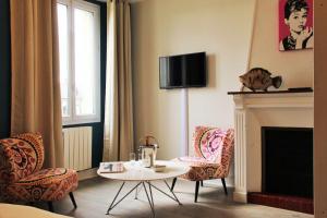 uma sala de estar com uma mesa e cadeiras e uma lareira em Picassiette em Chartres