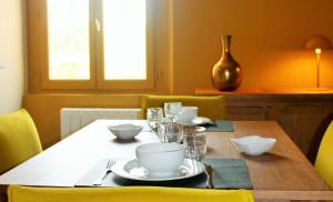 une table en bois avec des assiettes et des bols dans l'établissement Picassiette, à Chartres 8 autres photos