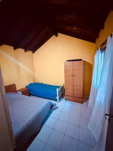 um quarto com 2 camas e uma cómoda e uma cama azul em La carmencita Club de Campo em Ingeniero J. Allan
