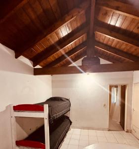 um quarto com 2 beliches e um tecto de madeira em La carmencita Club de Campo em Ingeniero J. Allan